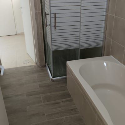 חדר אמבטיה עם מקלחון ודלתות זכוכית