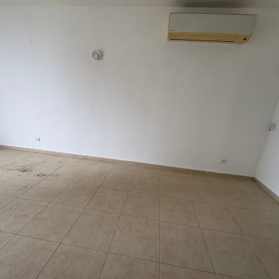 חדר ריק עם מזגן על הקיר ורצפת אריחים