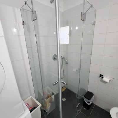 מקלחון זכוכית עם ראש מקלחת ומוצרי רחצה