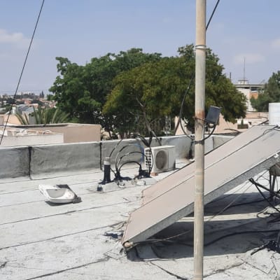 גג עם קולטי שמש ודודי מים, חיבורים ואיטום