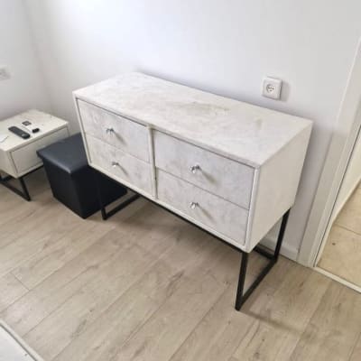 שידה לבנה עם מגירות על רצפת עץ