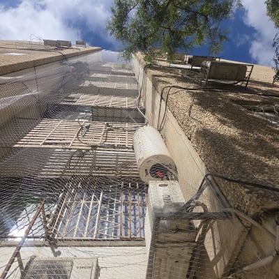 התקנת רשת נגד יונים במסתור כביסה בחזית בניין מגורים
