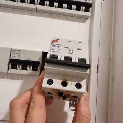 מפסק חשמלי עם סימני שריפה ביד חשמלאי