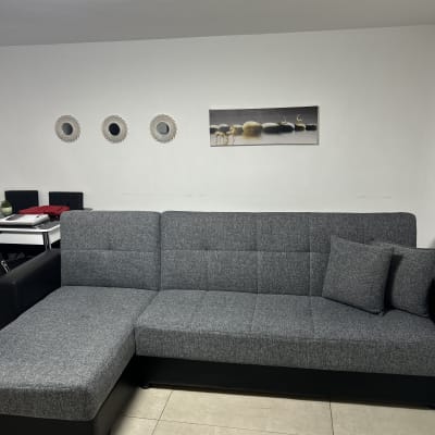 ספה אפורה בחדר מגורים עם כריות