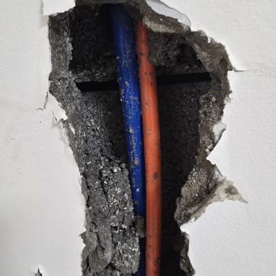 צינורות כחולים ואדומים בקיר שבור