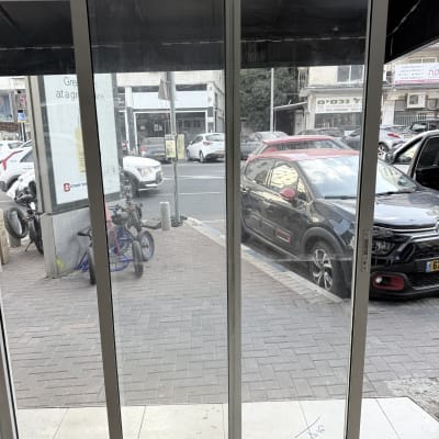 דלת זכוכית עם נוף לרחוב ומכוניות חונות