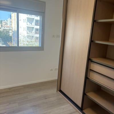 חדר ריק עם ארון עץ ורצפת פרקט נקייה