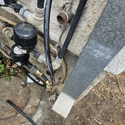 צינורות מים, ברזים ומחברים על קיר חיצוני