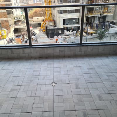 מרפסת נקייה עם רצפת אריחים ומרזב ניקוז