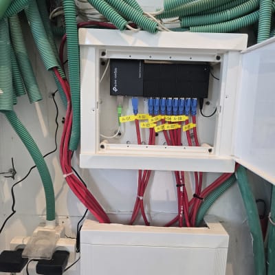 ארון תקשורת עם כבלים צבעוניים ומתג רשת