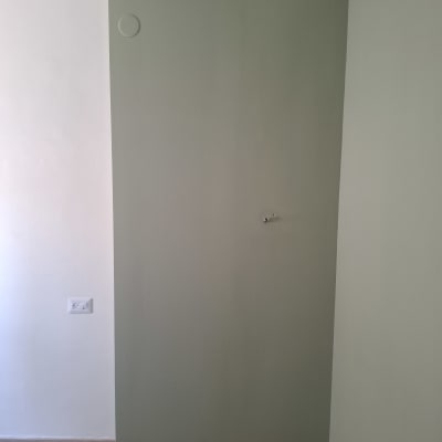 קיר ירוק עם שקע חשמל ורצפת עץ