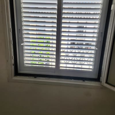 חלון עם תריסי אלומיניום פתוחים למחצה