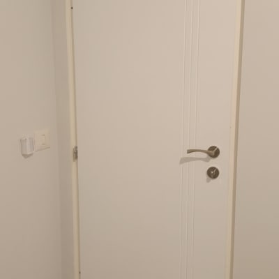 דלת לבנה עם ידית מתכת בחדר פנימי