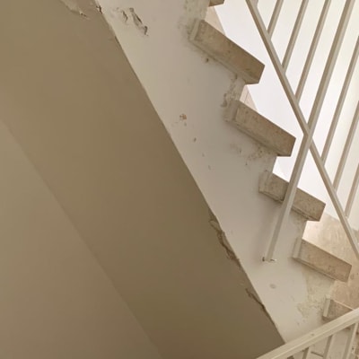 קיר מדרגות עם קילופי צבע ותיקונים