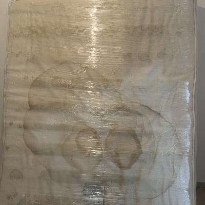 מזרן עטוף בניילון עם כתמים, מוכן להובלה