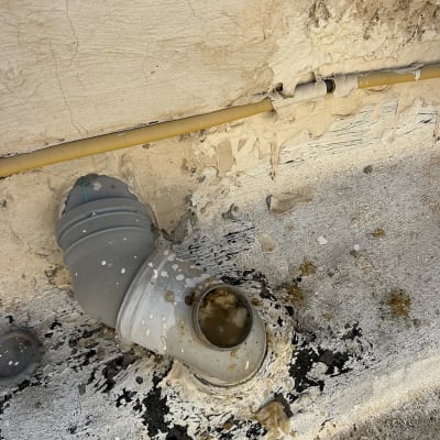 צינור ביוב עם נזילה על קיר חיצוני