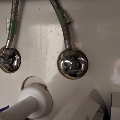 צינורות מים מתכתיים עם ברזים מתחת לכיור