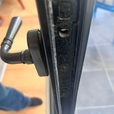 ידית מתכת על מסגרת דלת עם חור ברגים