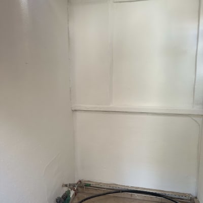 קיר צבוע בלבן עם צינורות בתחתית