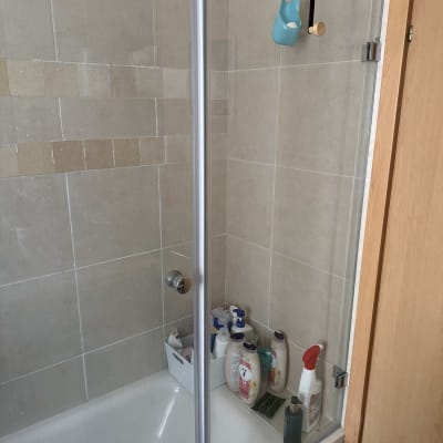 מקלחת עם בקבוקי סבון ומתקן תלייה