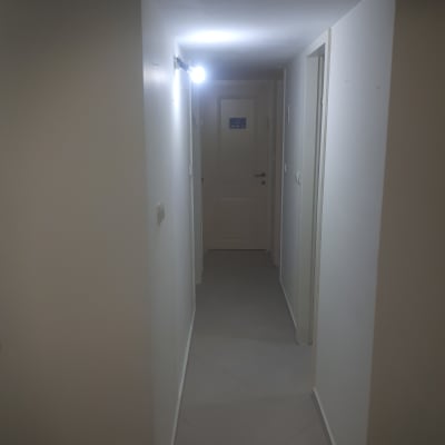 מסדרון עם קירות צבועים בלבן ותאורה חזקה