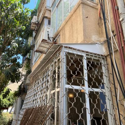 גג מתכת קטן מעל חלון עם סורגים