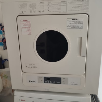 מכונת כביסה ומייבש עם מוצרי ניקוי בצד
