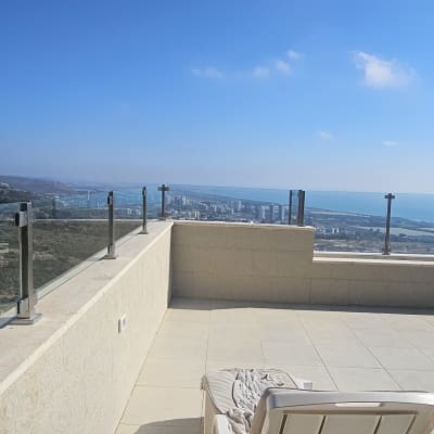 מרפסת עם נוף לעיר וכיסא נוח