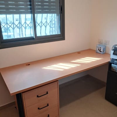 שולחן עץ עם מגירות ליד חלון