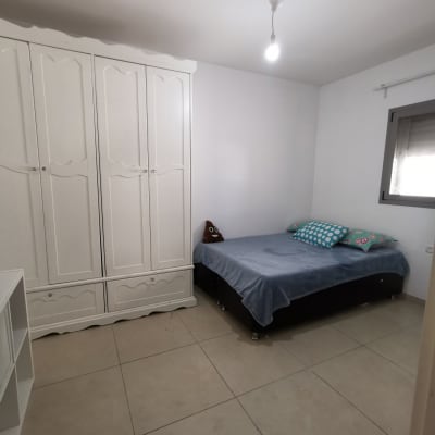 חדר שינה עם ארון בגדים ומיטה מסודרת