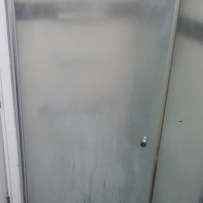 דלת זכוכית חלבית למקלחת עם רצפת אריחים כהה