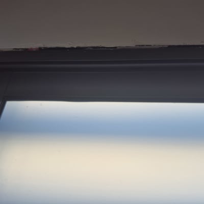 מסגרת חלון עם תיקוני צבע בקיר