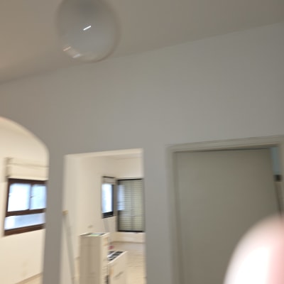 חדר צבוע בלבן עם חלונות ודלתות