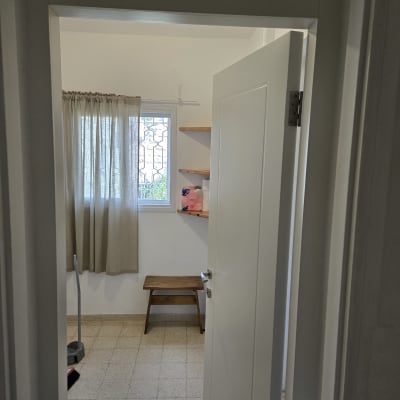 דלת פנים לבנה מעוצבת מותקנת בפתח חדר