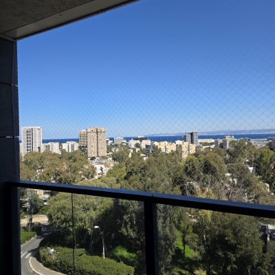 רשת יונים מותקנת על מרפסת עם נוף עירוני