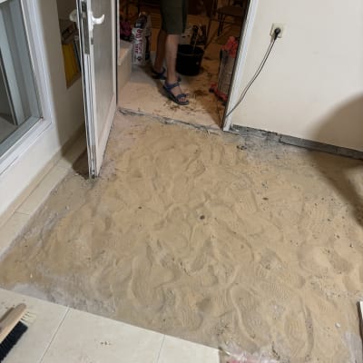 אדם עומד ליד אזור עבודה עם חול וכלים