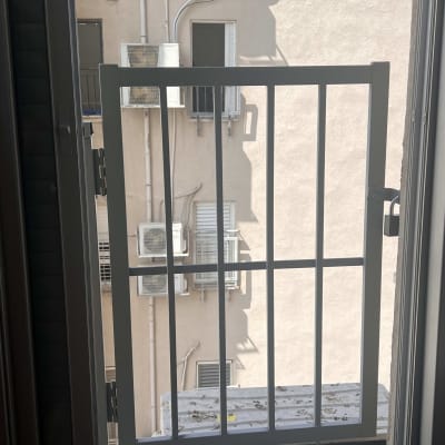 מסגרת חלון מתכתית עם סורגים מול קיר חיצוני