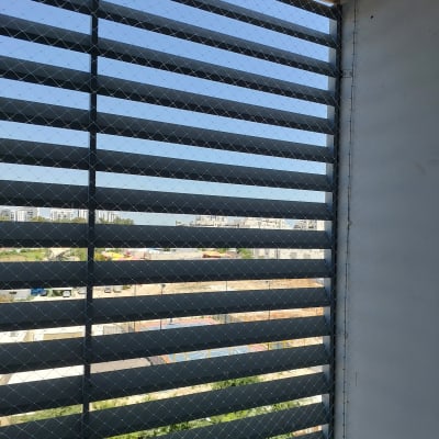 רשת מתכת על חלון למניעת כניסת יונים