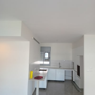 מטבח עם קירות צבועים בלבן, דלי צהוב על השיש