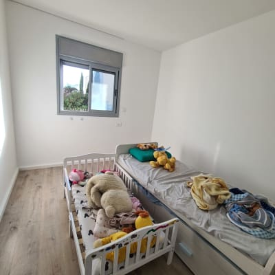 חדר ילדים עם קירות צבועים בלבן ומיטות ילדים