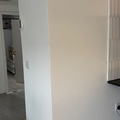 קיר עם אריחים, שקע חשמל וכבל חשמלי