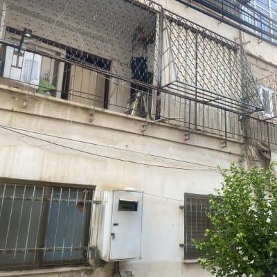 אדם עובד על גג מרפסת עם סולם