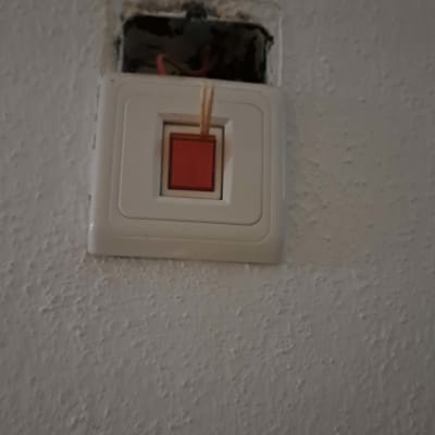 מתג חשמלי על קיר עם חוטים חשופים