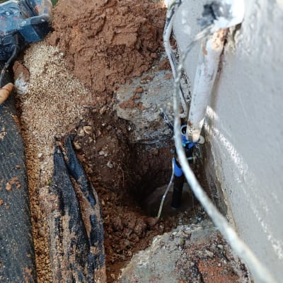 עבודת חפירה ותיקון צנרת ליד קיר חיצוני
