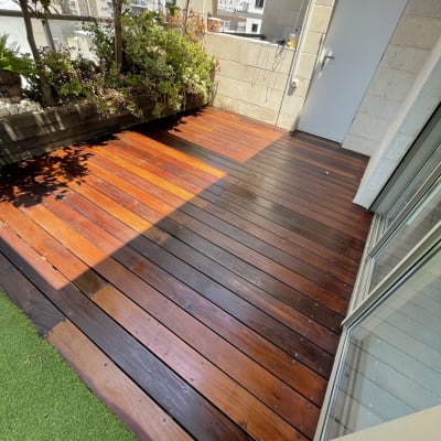 דק עץ בגינה עם צמחייה מסביב