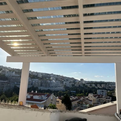 פרגולה מעץ עם גג שקוף בחצר