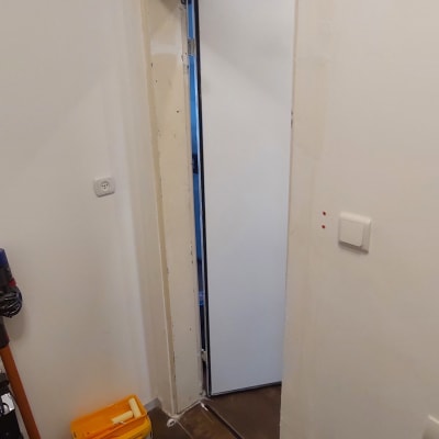 דלי צבע וגלגלת צביעה ליד דלת פתוחה