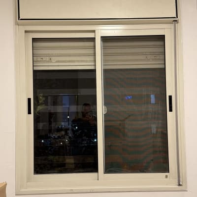 חלון עם תריסים סגורים ומסגרת לבנה