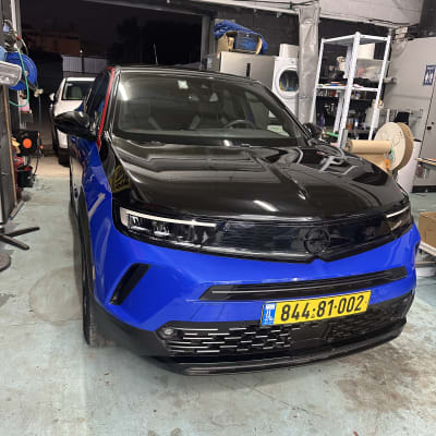 רכב כחול ושחור במוסך עם ציוד דיטיילינג סביבו