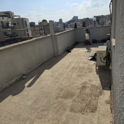 מרפסת עם כלים לאיטום, דלי וצינור